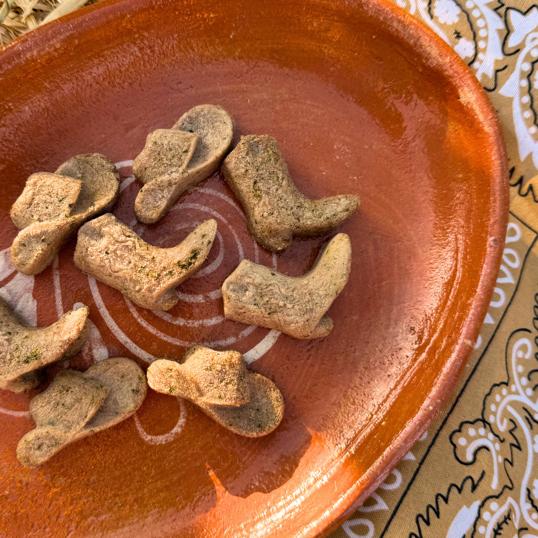Cowboy boot-shaped cookies on a terracotta plate with a patterned background